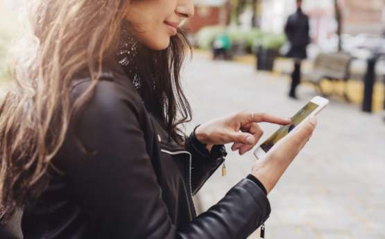 A young lady using her Mobile phone outside